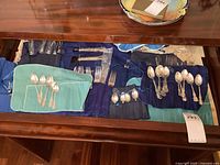 Drawer overview showing three fabric rolls holding spoons and forks alongside loose carving pieces