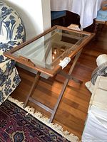 Rectangular wooden tray with glass insert positioned on separate wooden foldable stand, showing overall design and details.