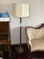Full view of the vintage floor lamp showing the height, shade, and base in a room setting with a sofa and piano nearby.