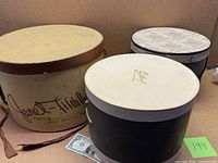 All three hat boxes with lids visible, size comparison with dollar bill
