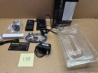 All components laid out including projector, cables, adapter, tripod, pouch, guide, blister tray, box