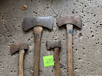 Four axes and hatchets laid out; shows heads and handles