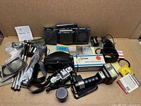 Wide view of entire lot showing camera, lens, flash, filters, poles, accessories, and Tamrac bag