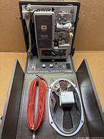 Projector opened showing mechanism, speaker panel, red cable