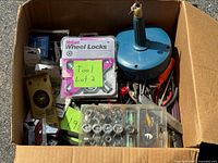 Box filled with assorted tools and packaged items visible
