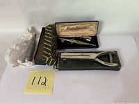 Group shot of three vintage tools: Brown & Sharpe punch, Paasche airbrush in case, XL hand punch on box