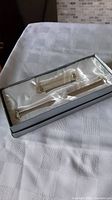 Scroll holder and display stand in original gift box on white cloth surface