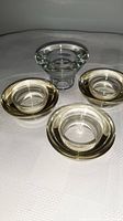 Overview of four glass votive candle holders, three matching and one different shape.