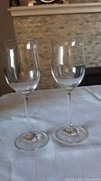 Pair of two clear Waterford crystal wine glasses standing side by side on white tablecloth, showing full height and shape.
