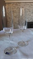 Pair of clear crystal champagne flutes on table with Marquis Waterford Crystal label on base