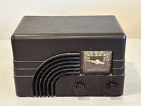 Front angle view of a black Bakelite rectangular AM tube radio by Northern Electric showing stepped curved grille and knobs