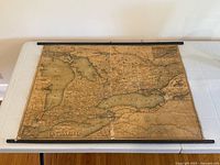 Full view of map laid flat on table showing top and bottom wooden rollers