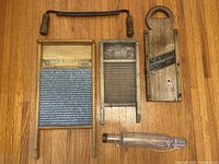 Full lot laid out on wooden floor including washboards, glass rolling pin, drawknife, and wooden food chopper