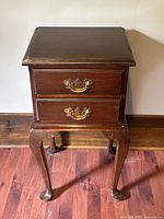 Front view of the antique mahogany side table showing the two drawers with brass handles and cabriole legs.