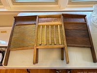 Overview of three antique washboards showing different wash surfaces and wooden frames with National Washboard Co. labels.