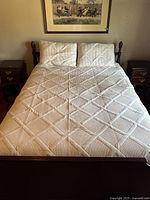 Front view of queen size white quilt spread on bed with two pillow shams.