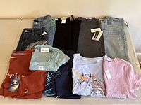 Lot of various folded girls clothing showing jeans, leggings, sweatshirts, t-shirts, all new with tags