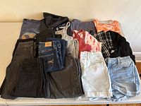 Assorted girls tops and bottoms folded together, showing color variety and styles