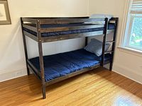 Side-angle view showing assembled bunk bed with mattresses and bedding