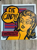Full frontal image of the square canvas painting titled 'Eye Candy' showing pop art woman and colorful background with text.
