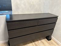 Front view of the IKEA dresser showing six drawers in two columns, dark brown finish