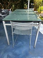 Rectangular frosted glass top patio table and metal chair showing size and materials