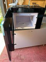 Open microwave showing interior with glass turntable and light.