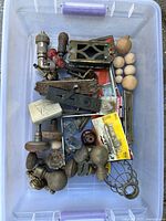 Full lot view showing all items in plastic bin including door knobs, plates, and wooden finials.