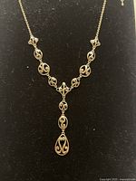 Close-up view of the gold filled decorative chain necklace showing the intricate oval and drop-shaped linked pendants with detailed scrollwork.