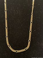 Long gold filled chain necklace displayed on a black velvet background showing chain details.