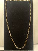 The 18k gold filled long chain necklace laid out straight against a black background to show full length and link style.