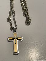 Front view of the heavy chain necklace with a silver plated cross pendant featuring gold plating in the center.