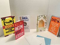 Five different Father's Day greeting cards propped up side by side with envelopes in front.