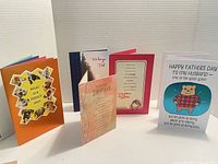 Front and inside view of five Father's Day cards standing on white surface with corrugated white background.
