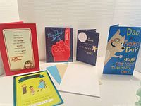 Five Father's Day cards displayed standing upright and show front designs and messages.
