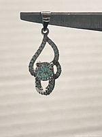 Front and angled view of the pendant showing the blue central Swarovski crystal surrounded by smaller clear crystals set in sterling silver.