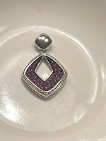 Front view of pendant showing the hollow square design filled with purple crystals and stamped .925 silver bail