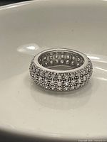 Front view of a sterling silver ring with multiple rows of small clear Swarovski crystals.