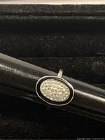 Clear image focusing on the front and top view of the silver ring with oval Swarovski crystal cluster.