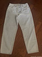 Full view of the light grey denim jeans laid flat showing front, waist, and leg style.