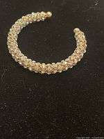 Open cuff bracelet with clear Swarovski crystals on a black background, showing the full open shape and crystal detailing.