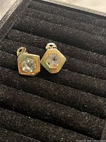 Photo showing hexagonal clip-on earrings with clear Swarovski crystals in the center, gold plated backing.