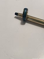 Full view of the vintage mood ring on a pen, showing the color and condition of the band and stone.