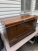 Front and top angled view of walnut cedar chest showing wood grain and surface finish.
