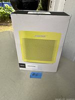 Front of retail box showing yellow Bose SoundLink Color II speaker image and branding