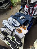 Hockey gear laid out with CCM Vector chest protector, Easton pants, various shin pads and gloves.