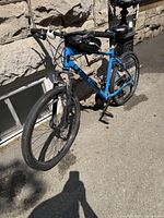 Blue Giant bicycle leaning against a stone wall, showing the full bike from front left angle.