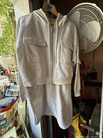 Front view of light grey cropped hoodie and long skirt set showing the zipper and pockets on the skirt.