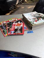 Photo showing a stack of CFL Illustrated magazines and a small group of CFL game day programs including a 1992 Grey Cup guide on a table.