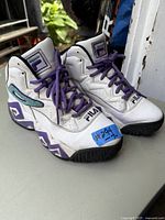 Pair of men's FILA running shoes white and purple with teal accents front and side view.